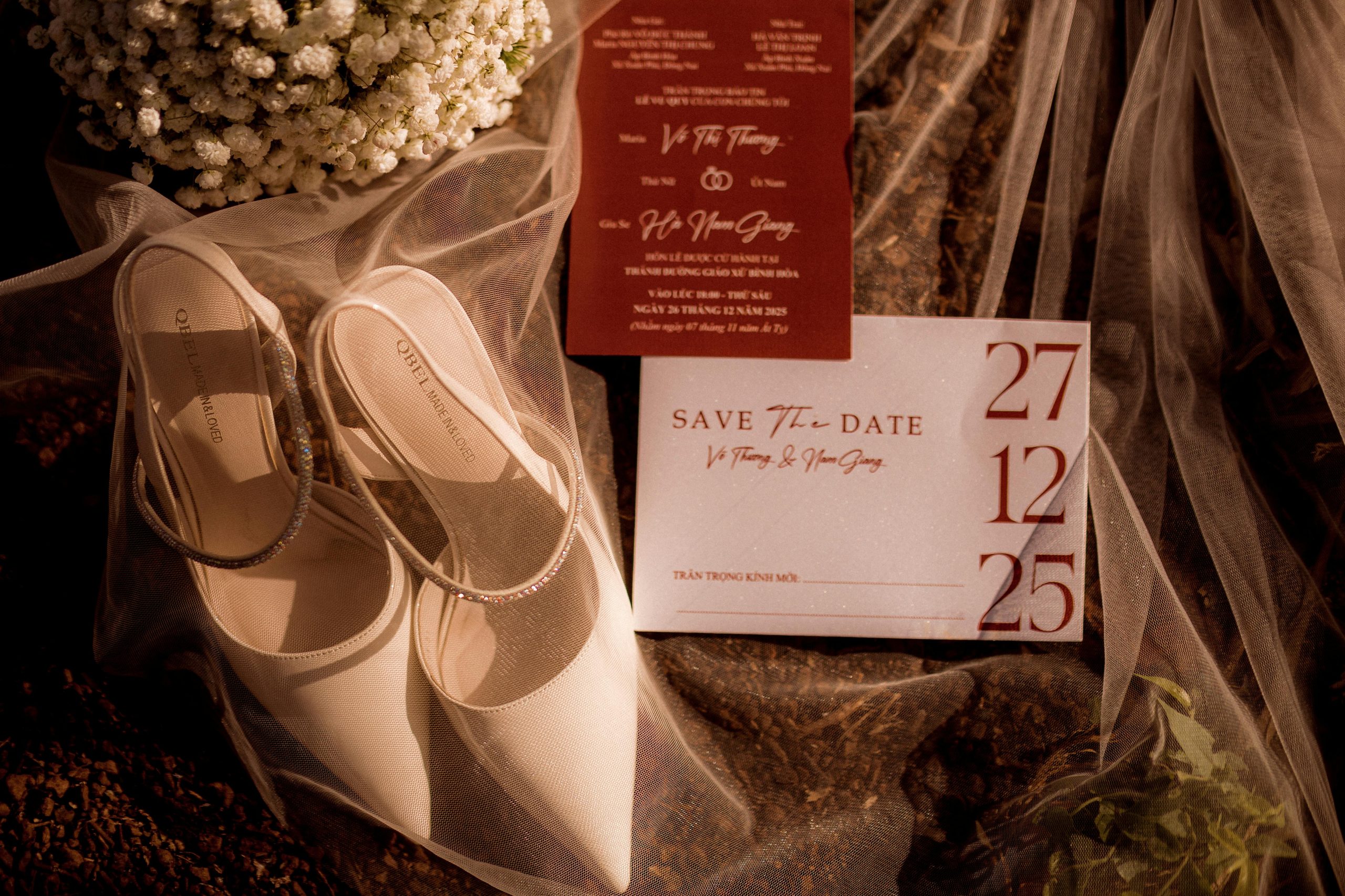 Romantic flat lay of wedding details including shoes, flowers, and save-the-date cards.